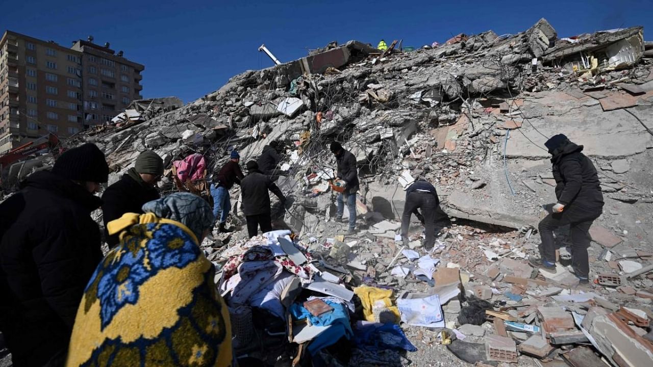 People search for missing relatives in the rubble of a collapsed building in the southeastern Turkish city of Kahramanmaras. Credit: AFP Photo