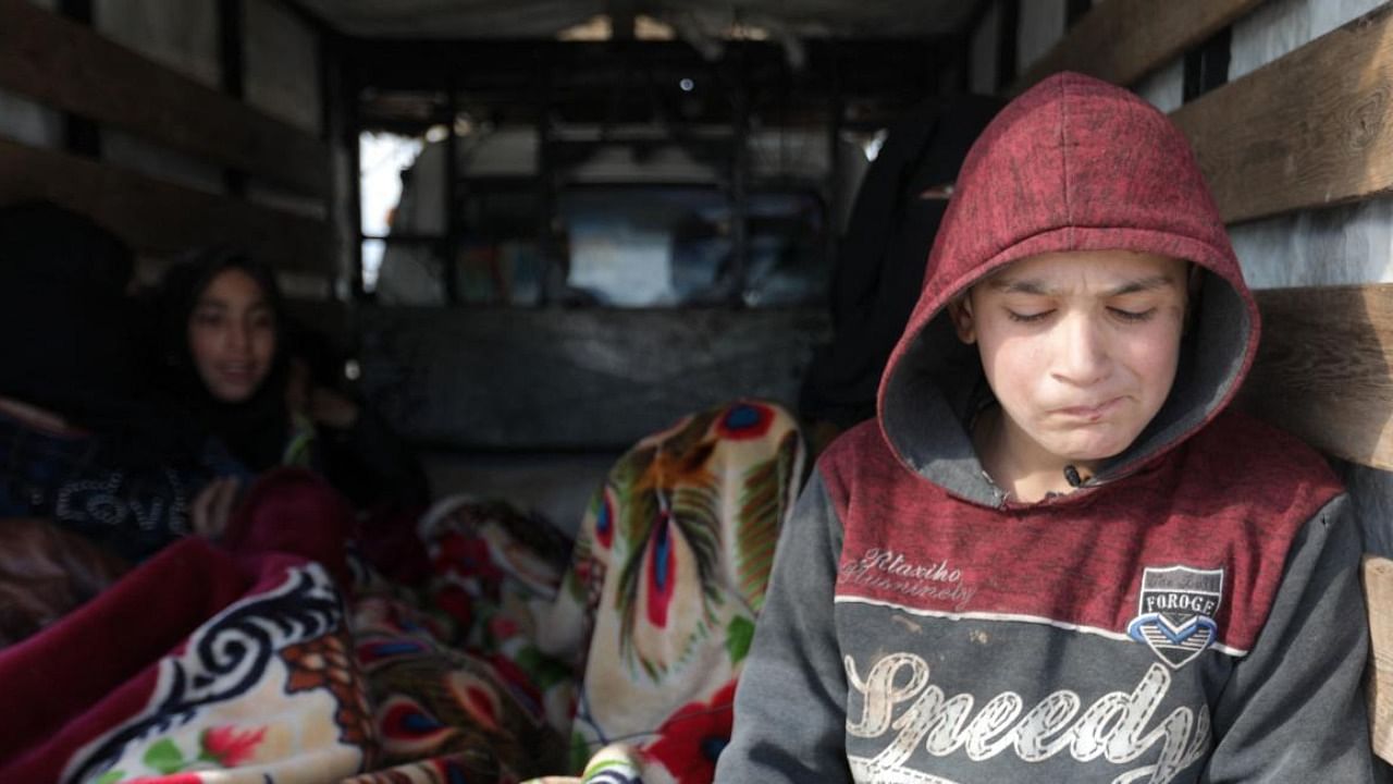 Syrians, displaced as a result of the deadly earthquake that hit Turkey and Syria, sit in a truck in outskirts of the rebel-held town of Jindayris. Credit: AFP Photo