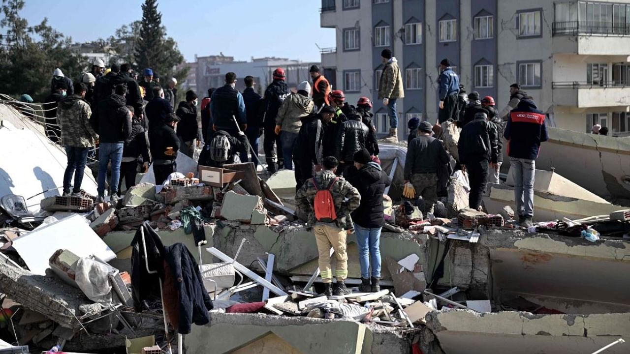 People wait as rescuers carry out search operations among the rubble of collapsed buildings in Kahramanmaras. Credit: AFP Photo