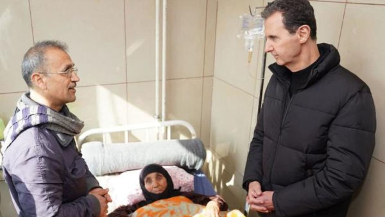 Syria's President Bashar al-Assad (R) visiting a wounded survivor of the earthquake, that hit Turkey and Syria, at a hospital in the northern Syrian city of Aleppo. Credit: AFP/HO/SANA