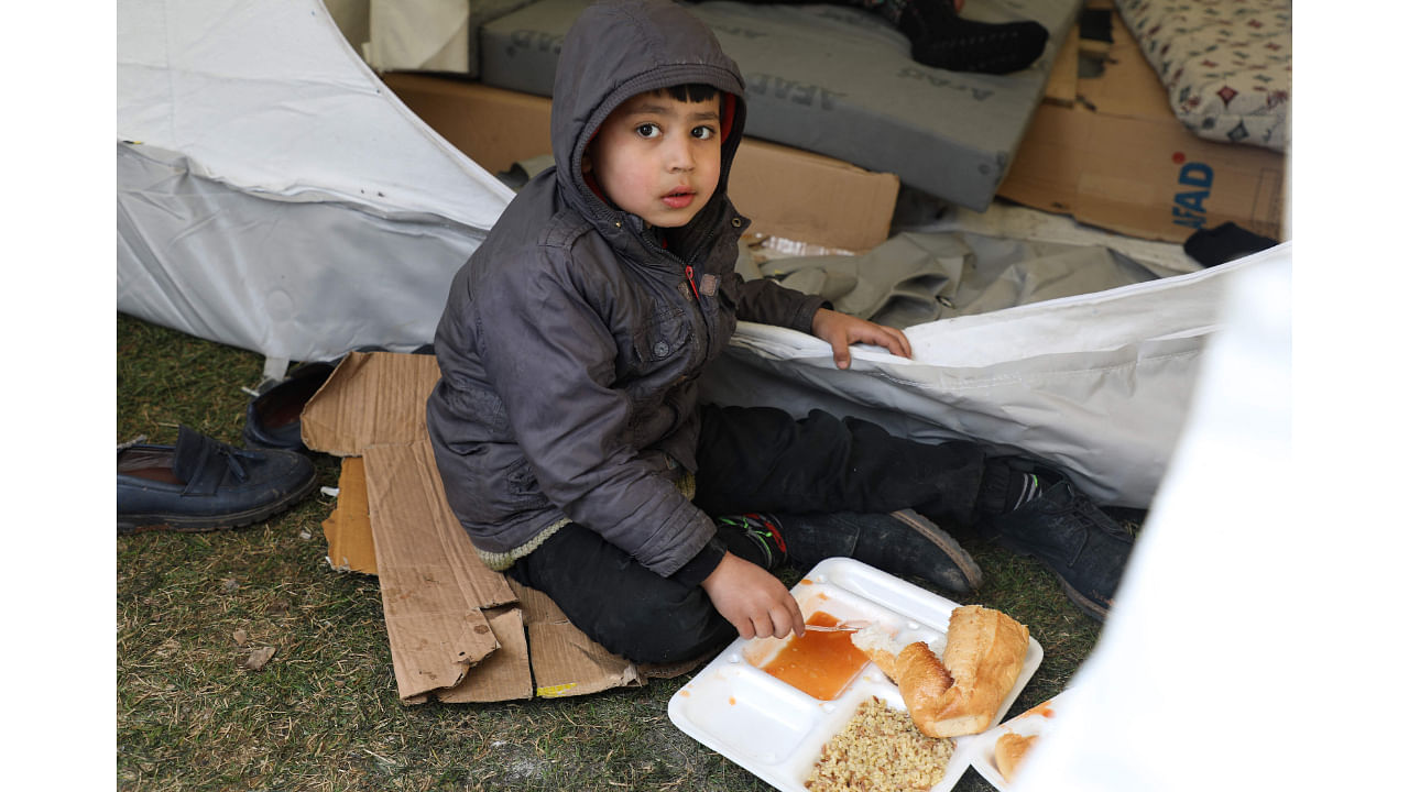 A child eats his meal received during a food distribution in a camp at Masal Park, in Gaziantep. Credit: AFP Photo