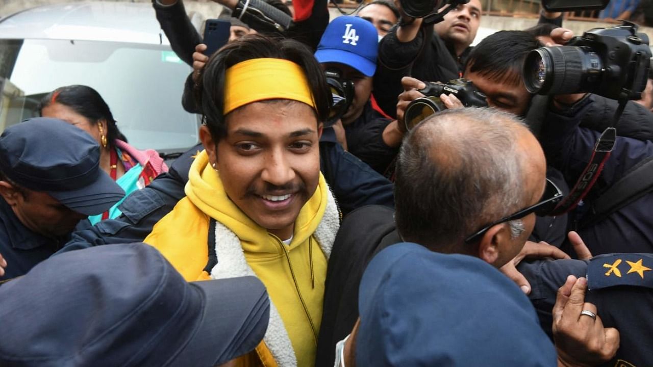 Sandeep Lamichhane (L) is escorted by police outside the districtl court following his release on bail. Credit: AFP File Photo 