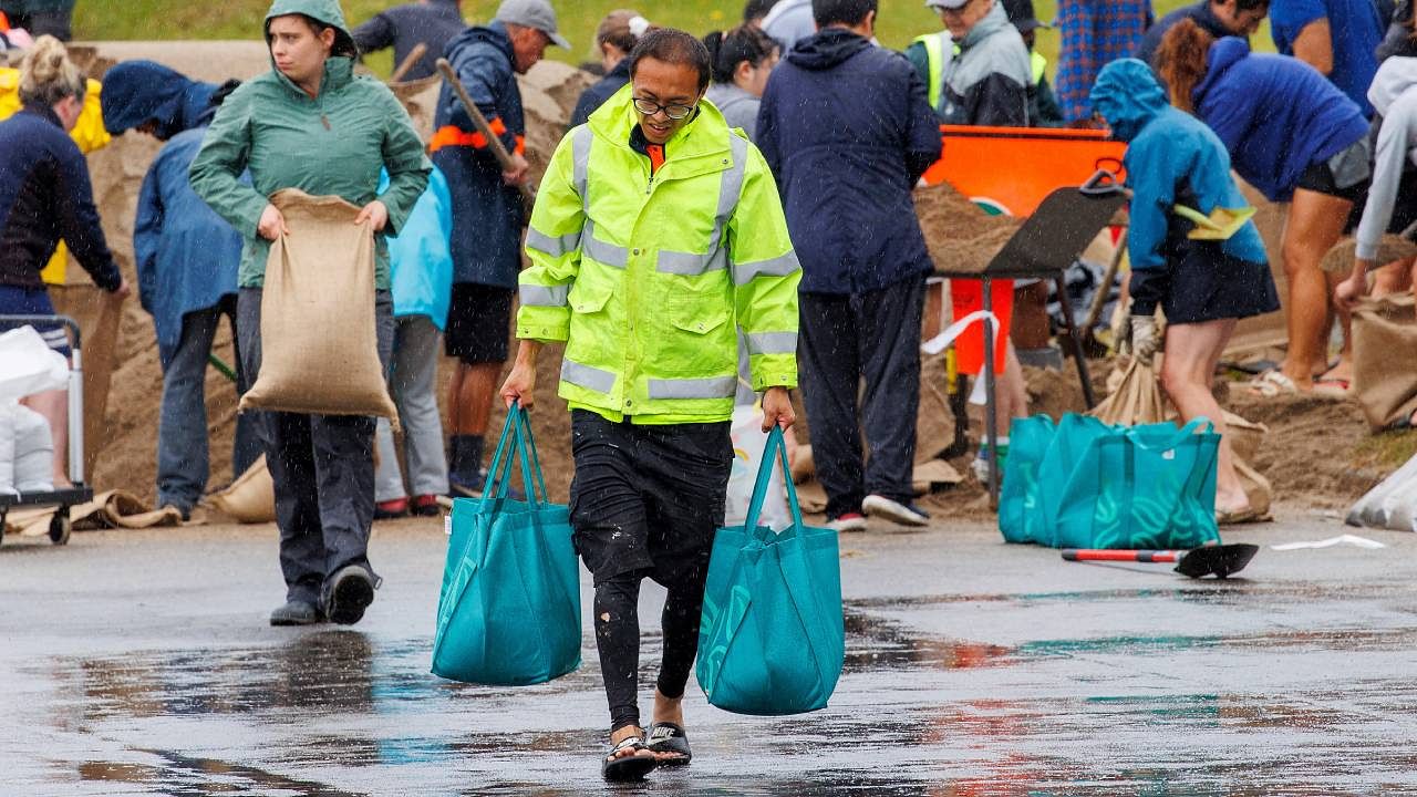 People fill up sandbags at a public collection point in preparation for the arrival of Cyclone Gabrielle in Auckland. Credit: Reuters Photo