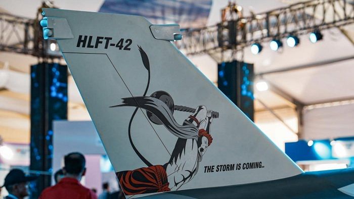 The tail of HAL's fighter aircraft with a portrait of Lord Hanuman in a pose striking with his mace with a message 'The storm is coming' displayed during the inauguration of Aero India 2023, at Yelahanka air base in Bengaluru. Credit: PTI Photo