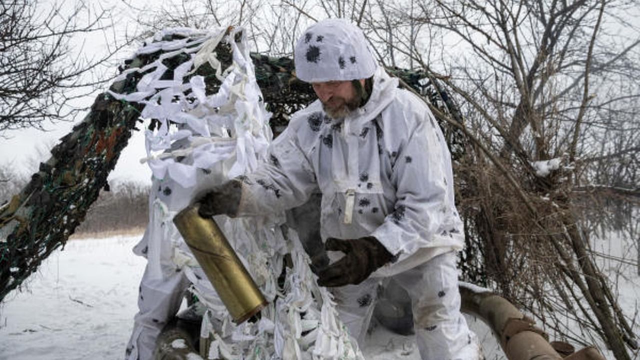 A Ukrainian serviceman of the 80th Air Assault Brigade holds an empty shell after firing an M119 Howitzer artillery weapon towards Russian troops, amid Russia's attack on Ukraine. Credit: Reuters Photo