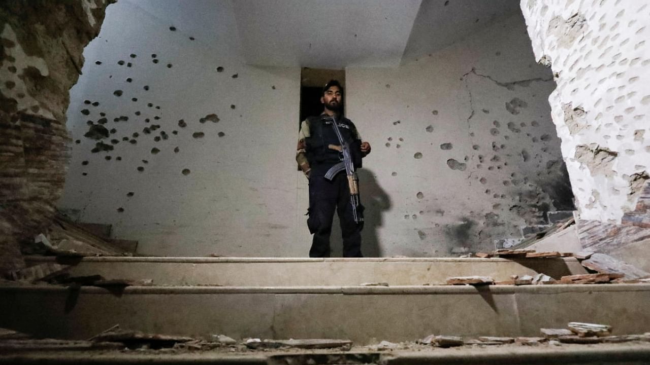 A police officer stands amid the damages in the aftermath of an attack on a police station in Karachi. Credit: Reuters Photo
