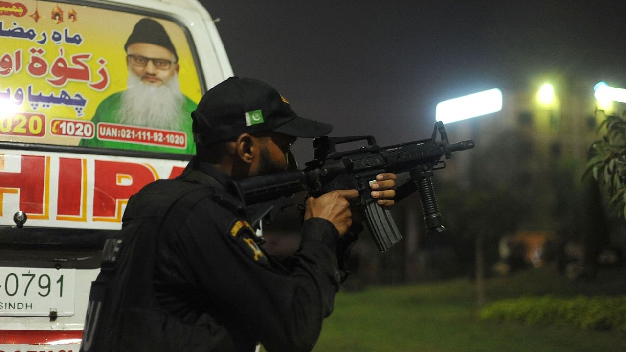 A policeman takes position near the site of an attack to a police compound in Karachi on February 17, 2023. Credit: AFP Photo