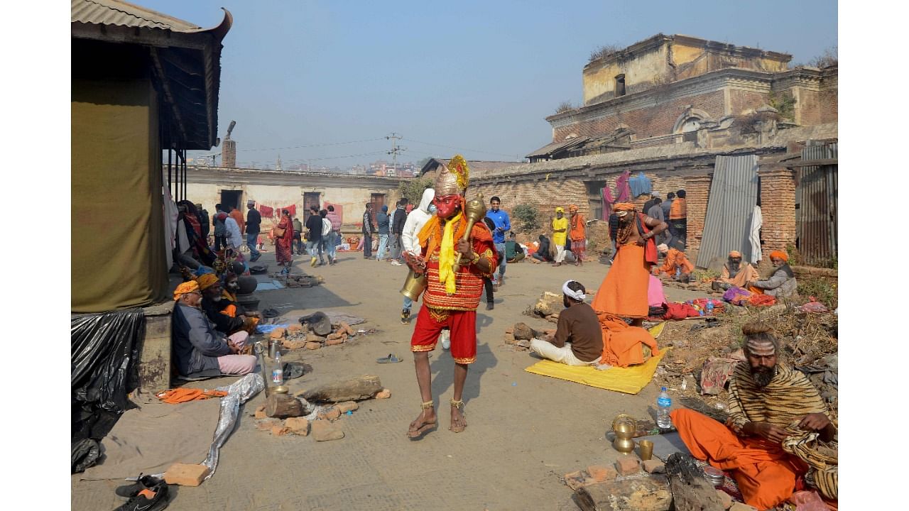 A Sadhu, Hindu holy man, wearing a mask of Hindu god Lord Hanuman walks during Maha Shivaratri festival at the Pashupatinath Temple in Kathmandu. Credit: AFP Photo