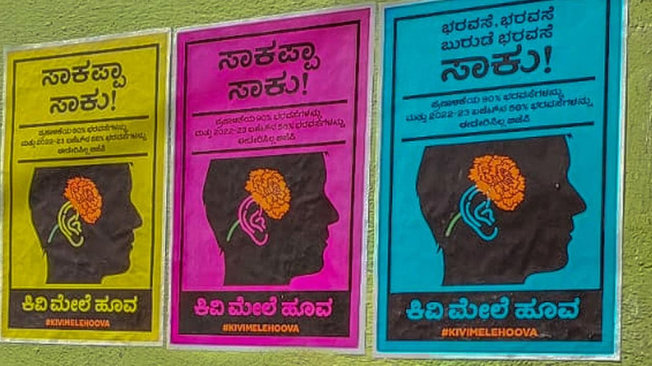 Congress workers pasted Kivi Mele Huva (flower on ear) posters at Subedar Chatram Road, Gandhi Nagar, in Bengaluru on Saturday. Photo Credit: Special arrangement