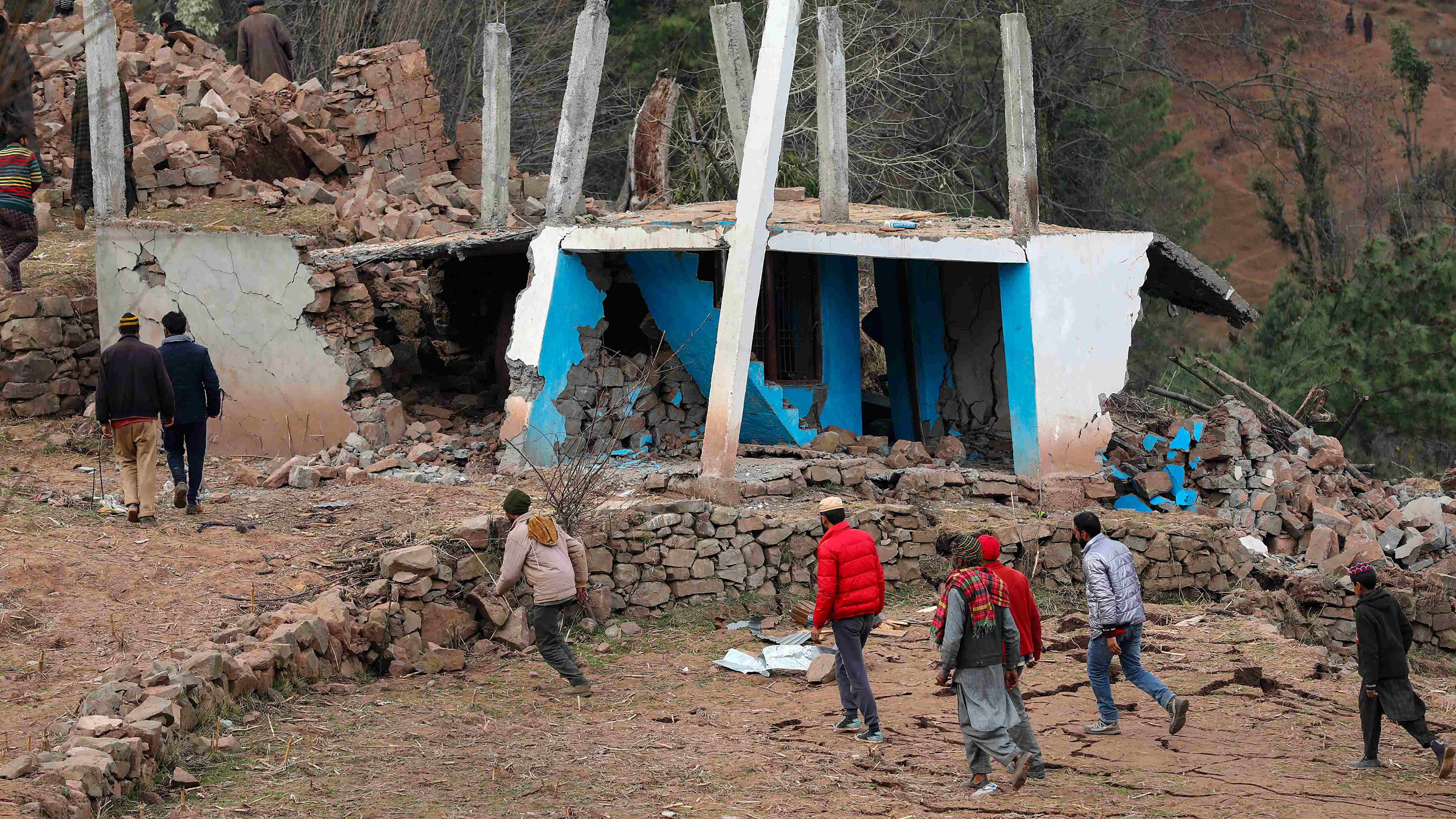 People move out of the spot after a lanslide that damaged several houses, at Duksar Dal in Ramban district. Credit: PTI Photo