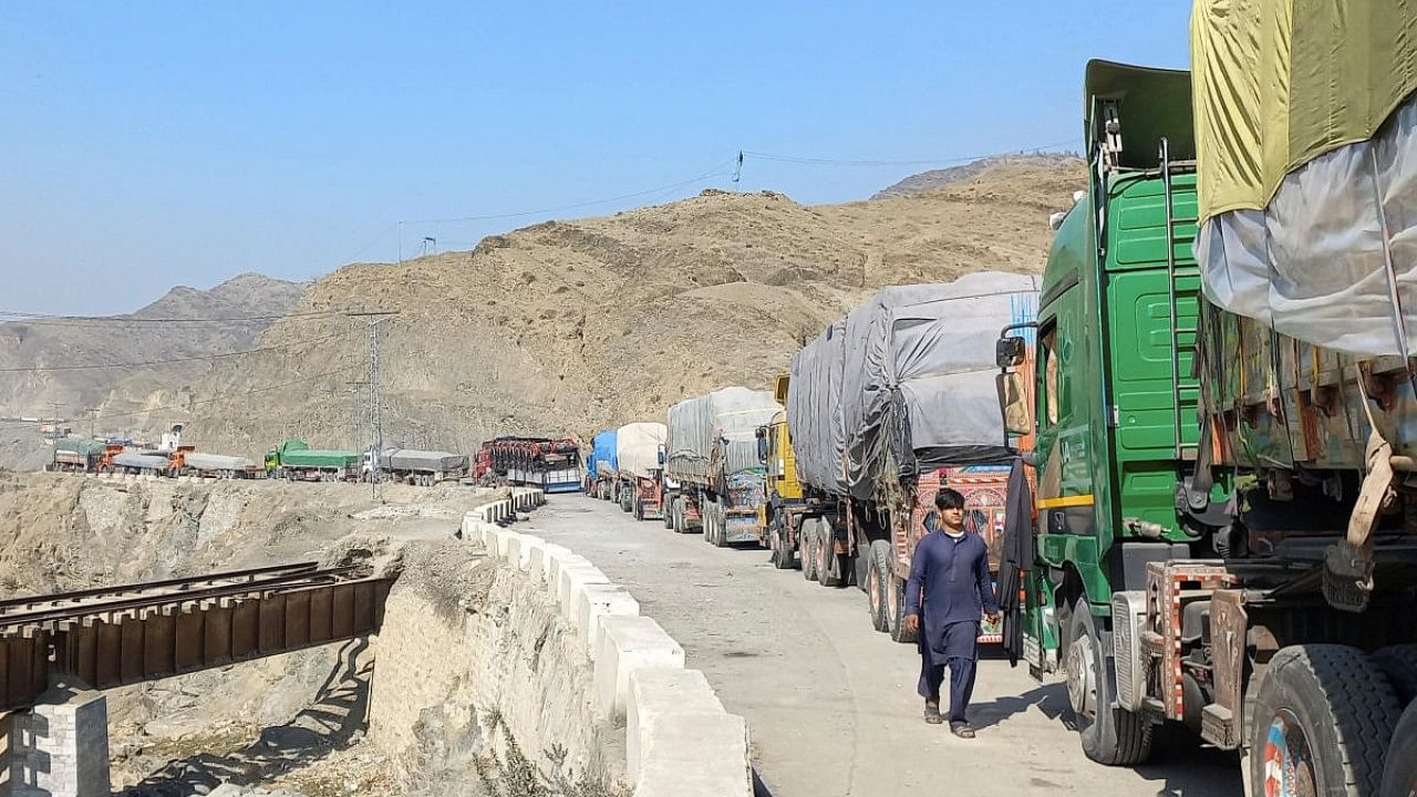 A man walks past trucks, loaded with supplies to leave for Afghanistan, seen stranded after Taliban authorities have closed the main border crossing in Torkham. Credit: Reuters Photo