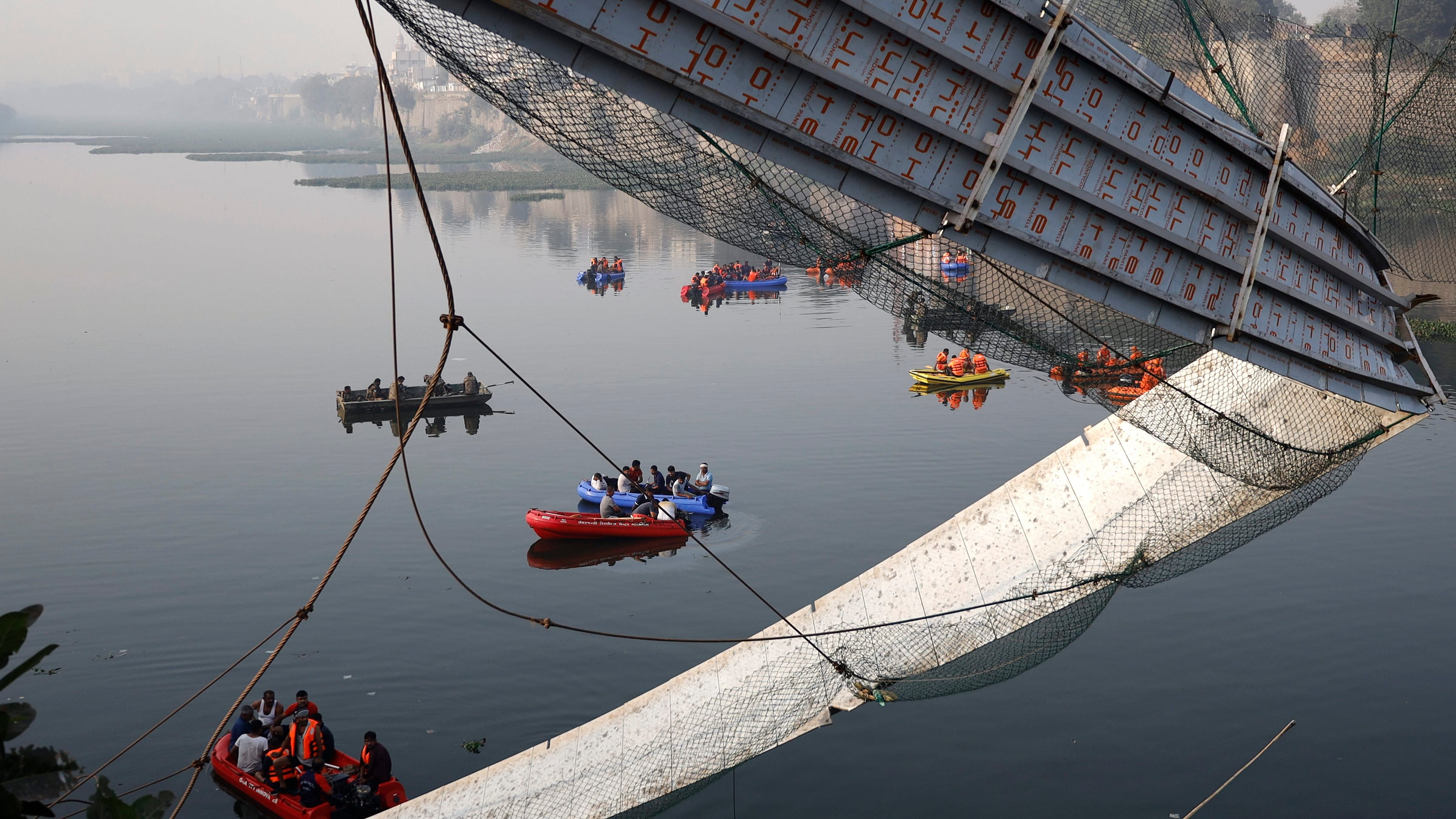 Morbi: Rescue operation underway after the collapse of a suspension bridge over the Machchhu river, in Morbi district. Credit: PTI Photo