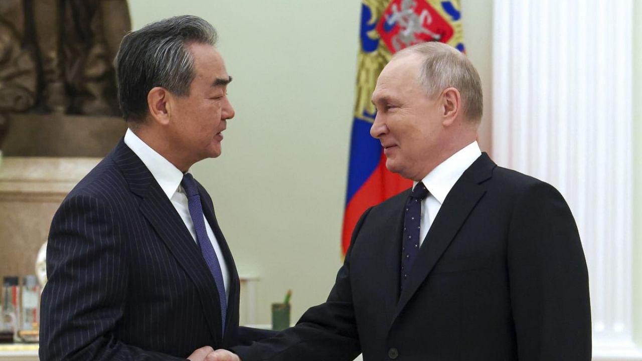 Russian President Vladimir Putin greets Chinese Communist Party's foreign policy chief Wang Yi during their meeting at the Kremlin in Moscow. Credit: AP/PTI Photo