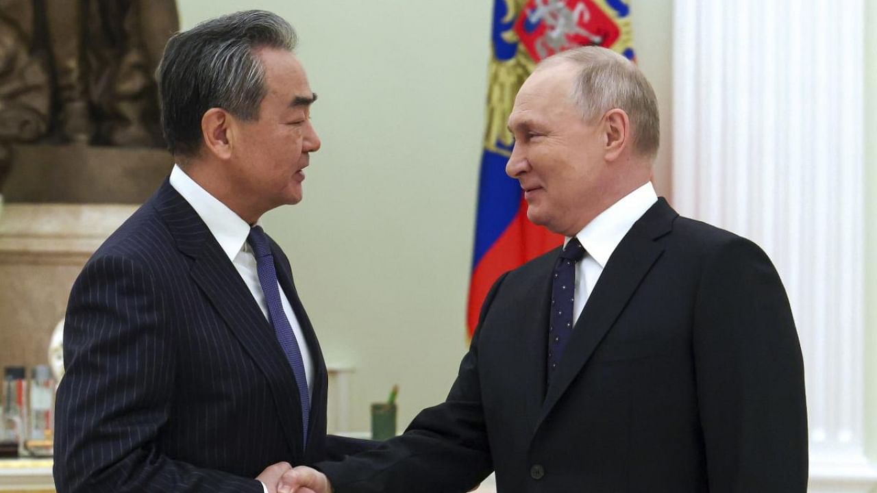 Russian President Vladimir Putin greets Chinese Communist Party's foreign policy chief Wang Yi. Credit: AP/PTI Photo