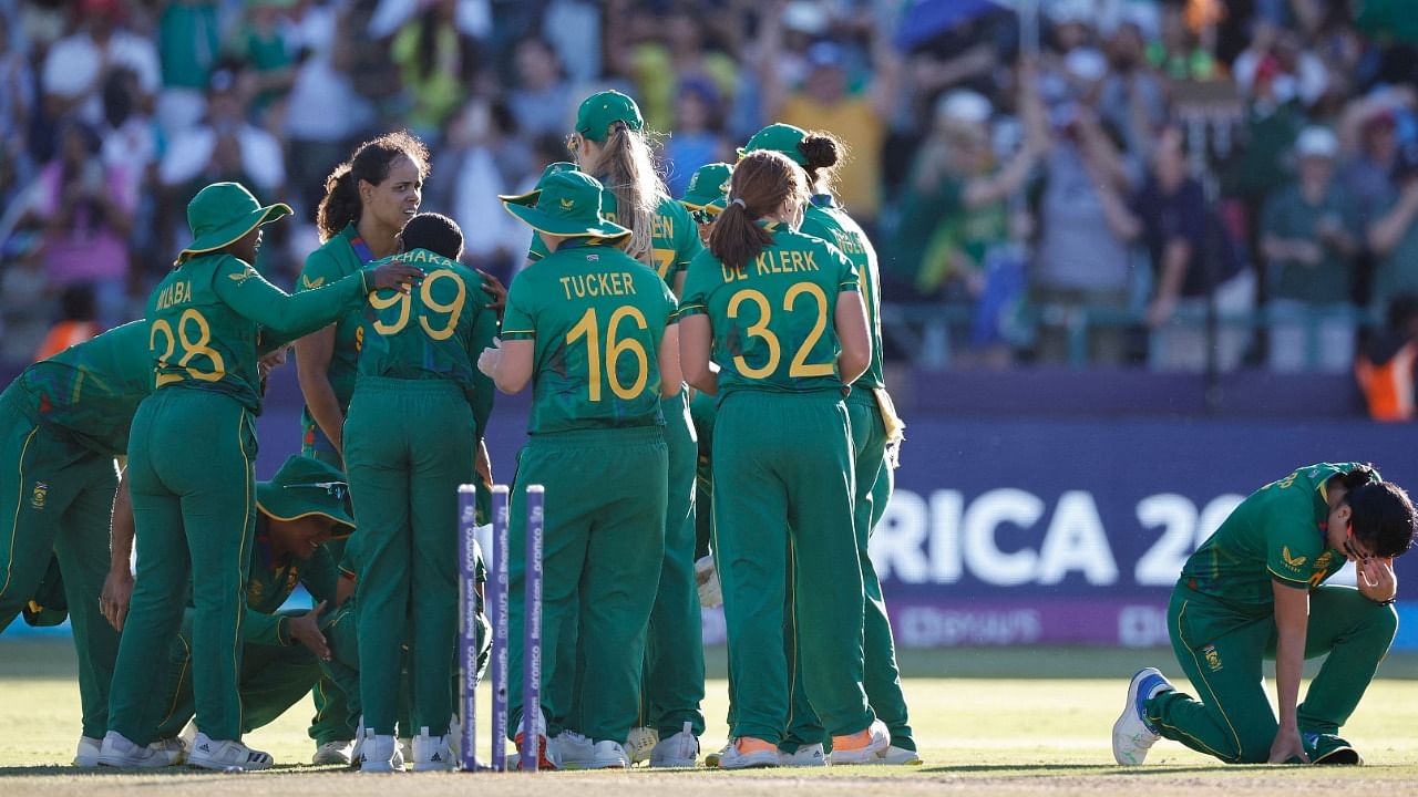 South Africa's Marizanne Kapp (R) kneels as South African playes celebrate winning the semi-final T20 women's World Cup cricket match between South Africa and England at Newlands Stadium in Cape Town. Credit: AFP Photo