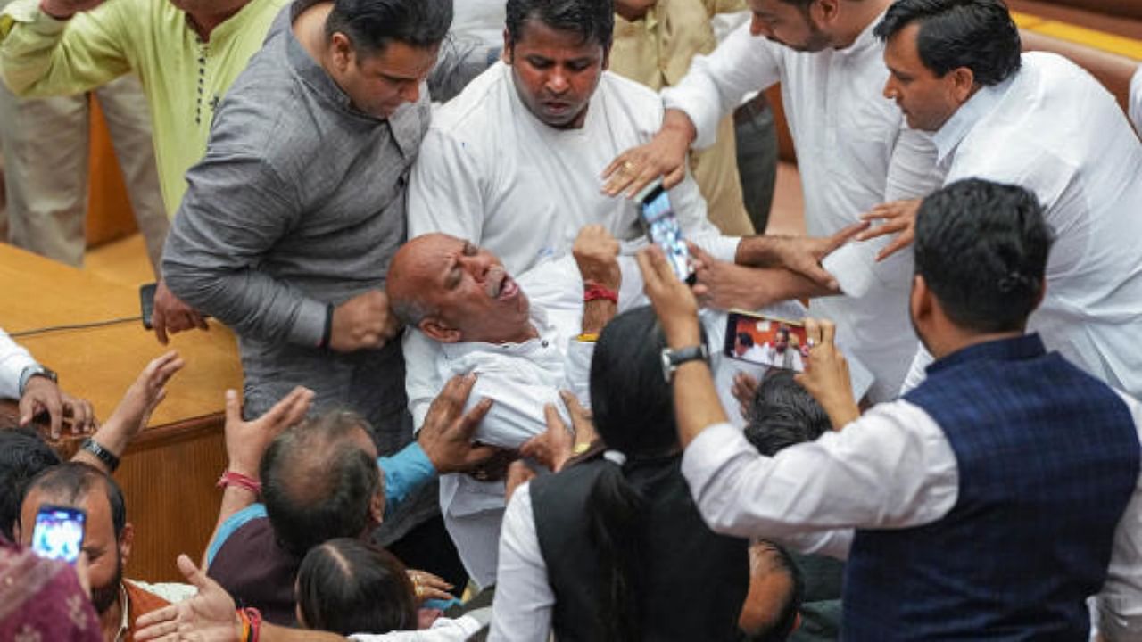 A councillor collapses amid clashes between councillors of AAP and BJP during the election of members of the MCD Standing Committee, at the Civic Centre in New Delhi. Credit: PTI Photo