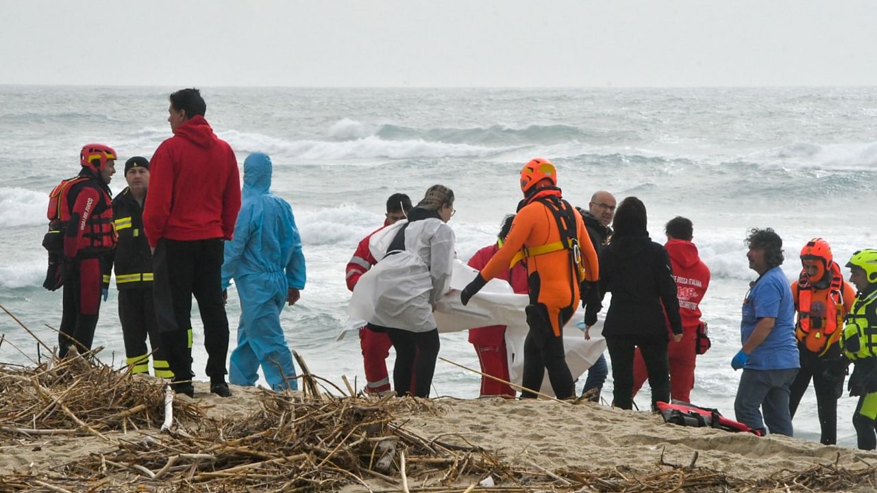 Rescuers recover a body at a beach near Cutro, southern Italy, after a migrant boat broke apart in rough seas, Sunday, February 26, 2023. Credit: AP via PTI