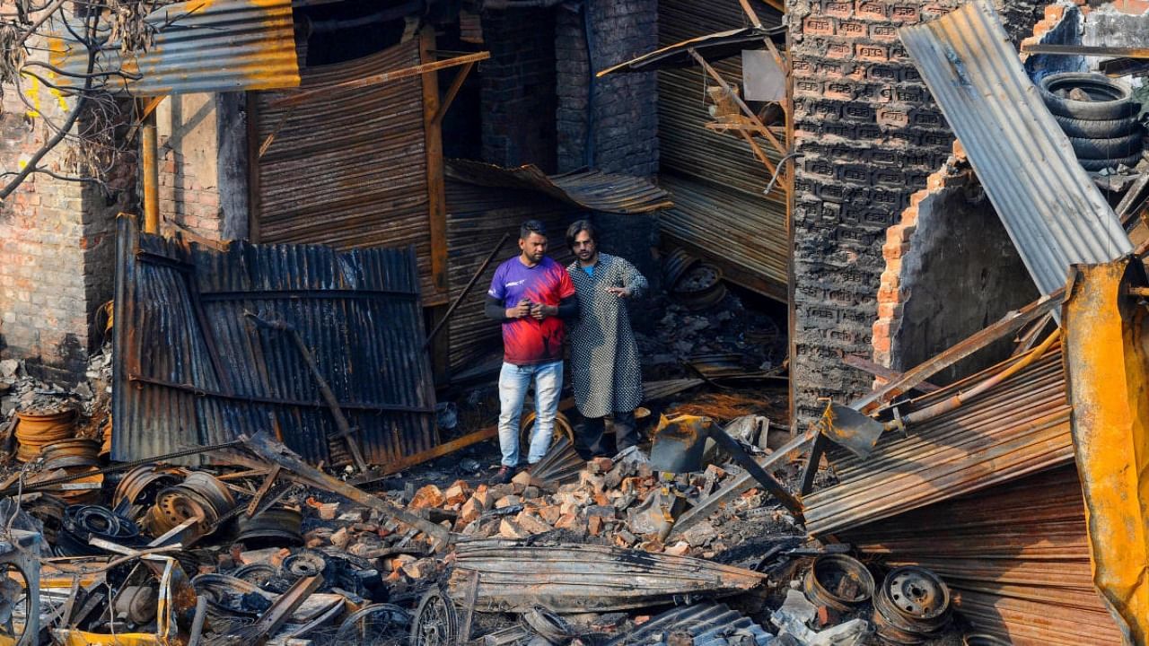 File photo of shop owners inspecting charred remains of shops in East Delhi after riots of 2020. Credit: PTI Photo