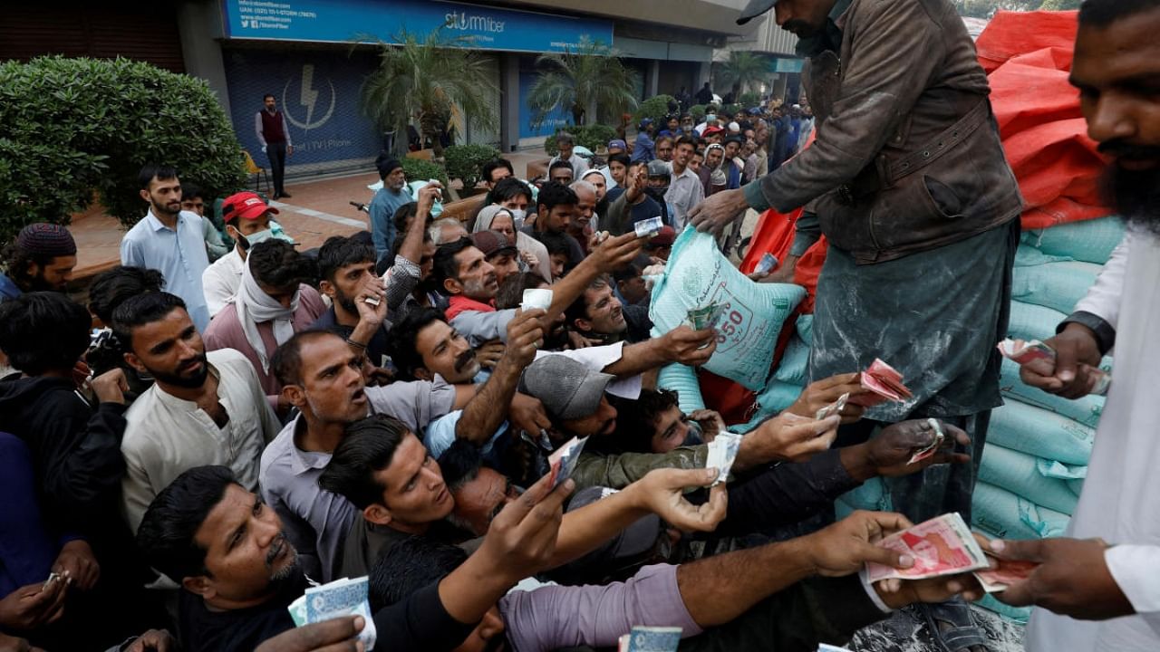 People reach out to buy subsidised flour sacks from a truck in Karachi, Pakistan. Credit: Reuters Photo