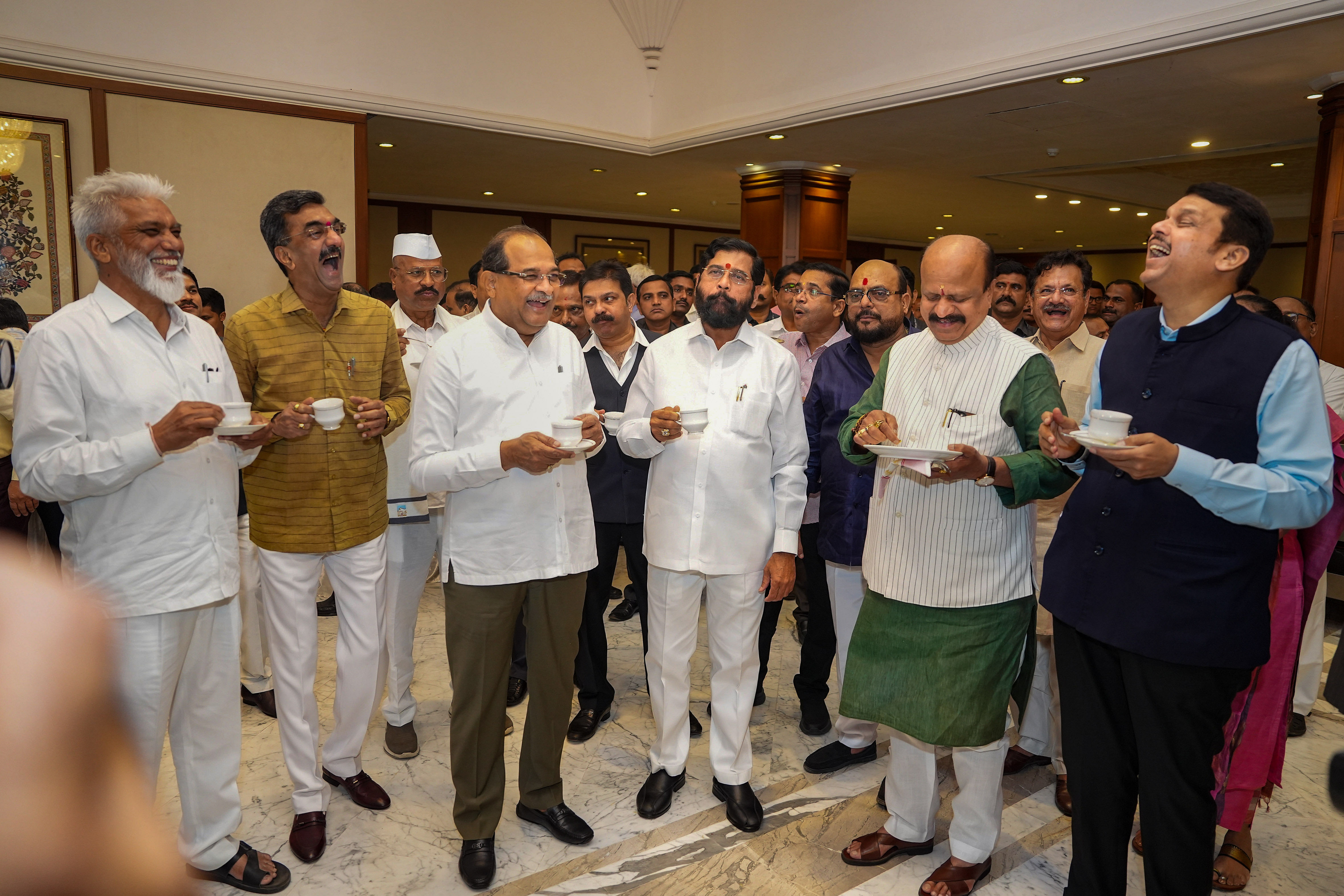 Maharashtra Chief Minister Eknath Shinde with Deputy Chief Minister Devendra Fadnavis and MLAs attends the customary tea party, on the eve of the Budget Session of the State Assembly. Credit: PTI Photo
