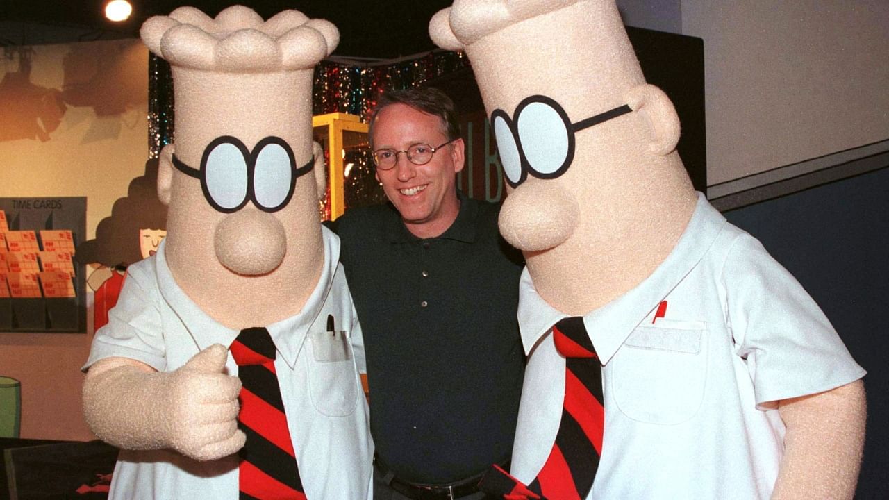 Scott Adams, the creator of "Dilbert", the cartoon character that lampoons the absurdities of corporate life, poses with two "Dilbert" characters at a party January 8, 1999 in Pasadena, Calif. Credit: Reuters Photo