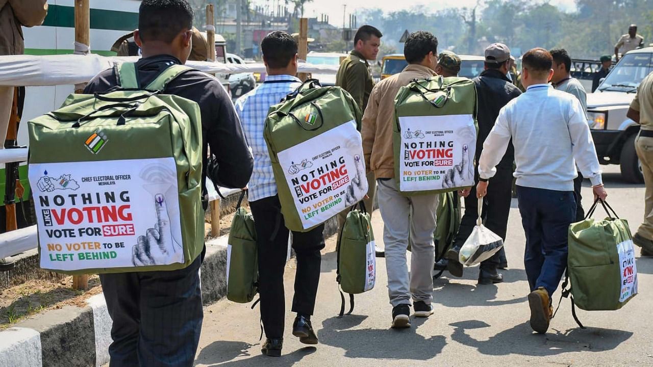 Polling officials leave for their respective polling stations after collecting EVMs and other election equipment from a distribution centre at Nongpoh in Ri Bhoi district. Credit: PTI Photo