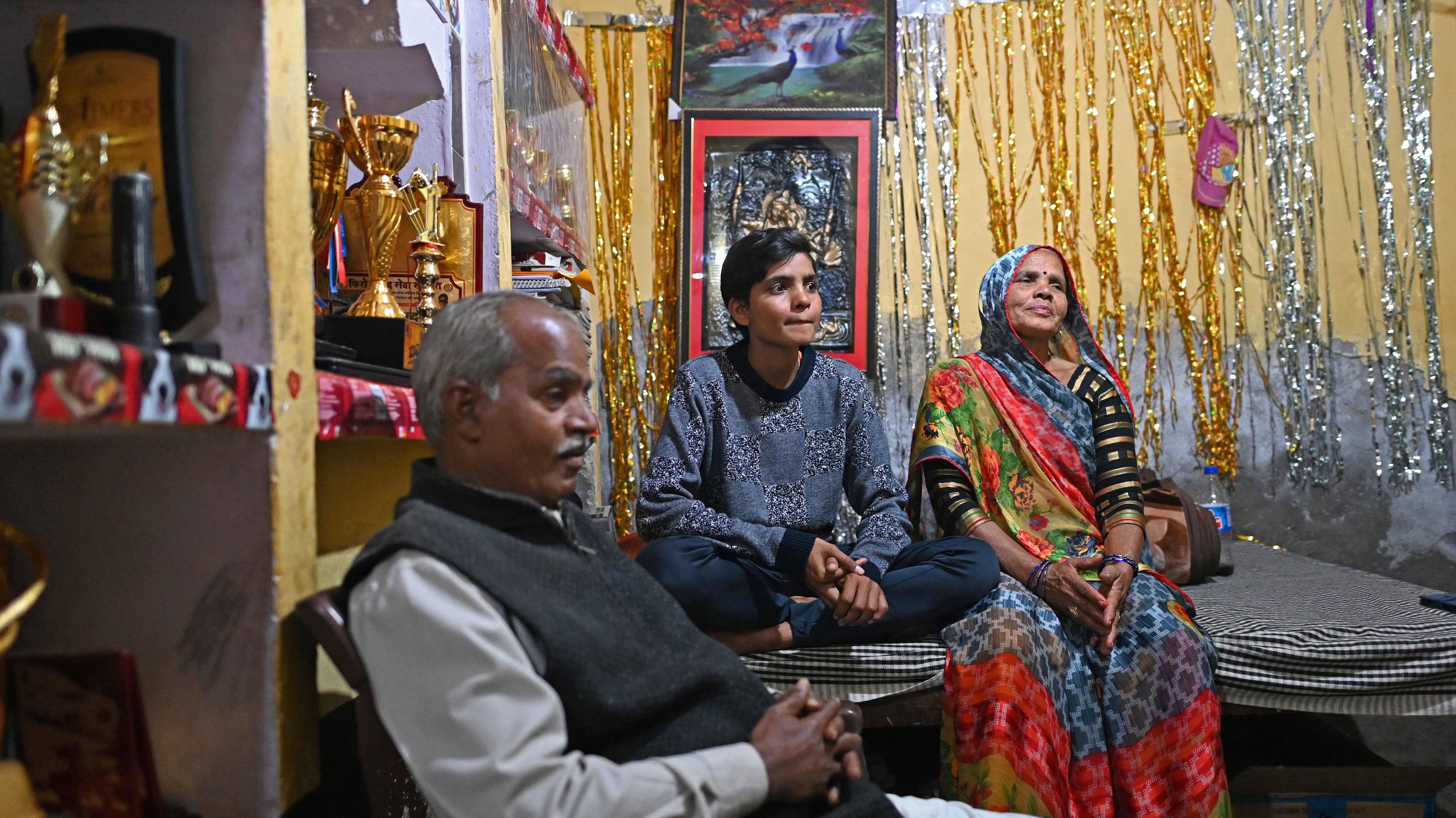 Sonam Yadav (C) sits with her parents Mukesh Kumar (L) and Guddi Devi in their house in Firozabad in Uttar Pradesh. Credit: AFP Photo