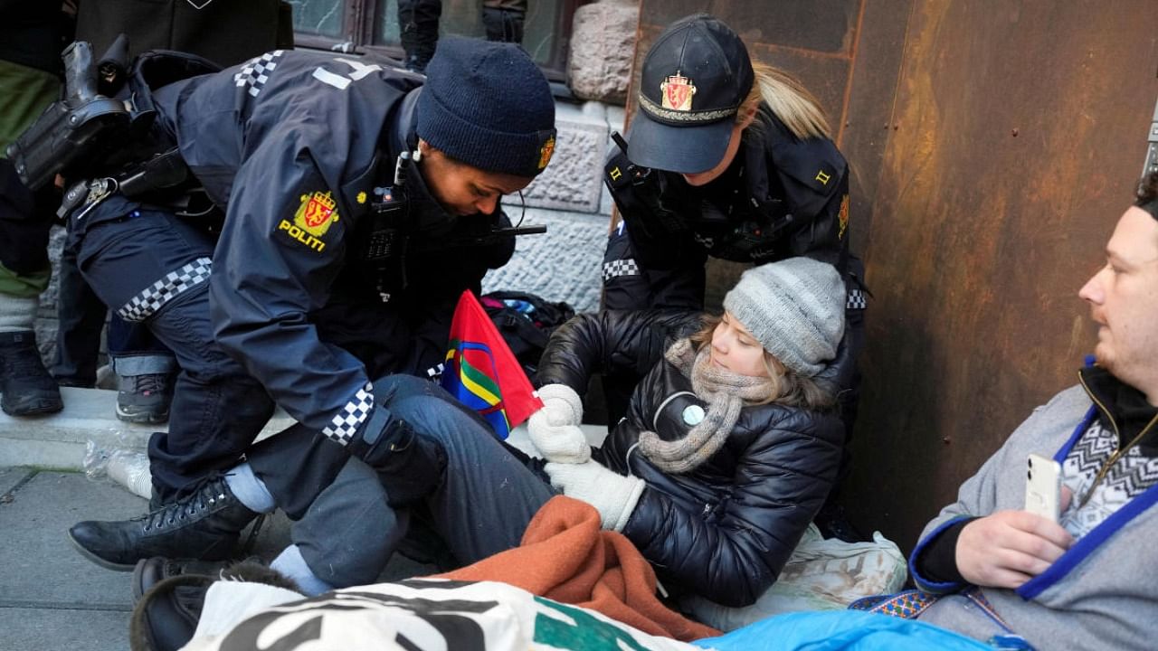 Thunberg, holding a red, blue, yellow and green Sami flag, was lifted and carried away by police officers while hundreds of demonstrators chanted slogans. credit: AFP Photo
