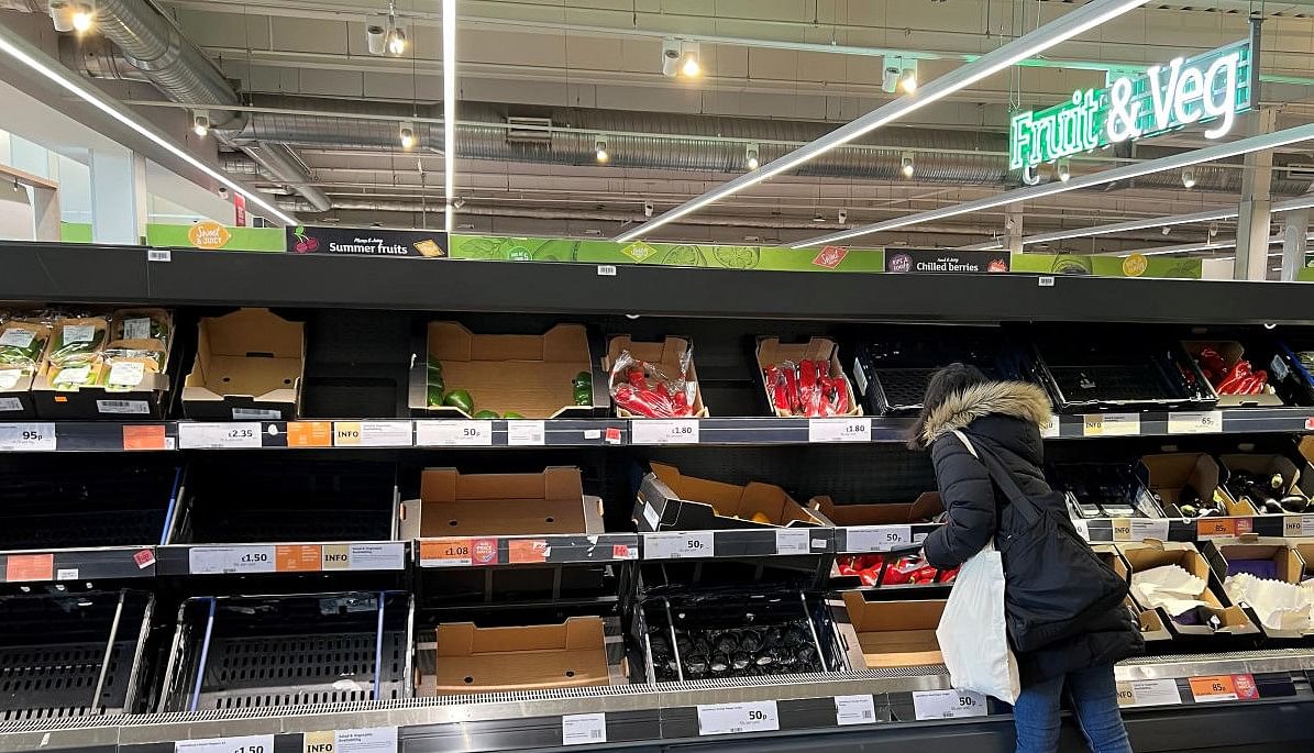 A shopper looks amongst a partially empty fruit and vegetable display in an aisle at a Sainsbury's supermarket, as Britain experiences a seasonal shortage of some fruit and vegetables, in London, Britain, February 26, 2023. REUTERS/Toby Melville