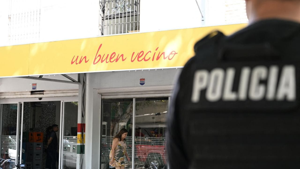 A police officer stands guard outside the supermarket that belongs to the family of Antonela Roccuzzo, wife of Argentine soccer star Lionel Messi. Credit: Reuters Photo