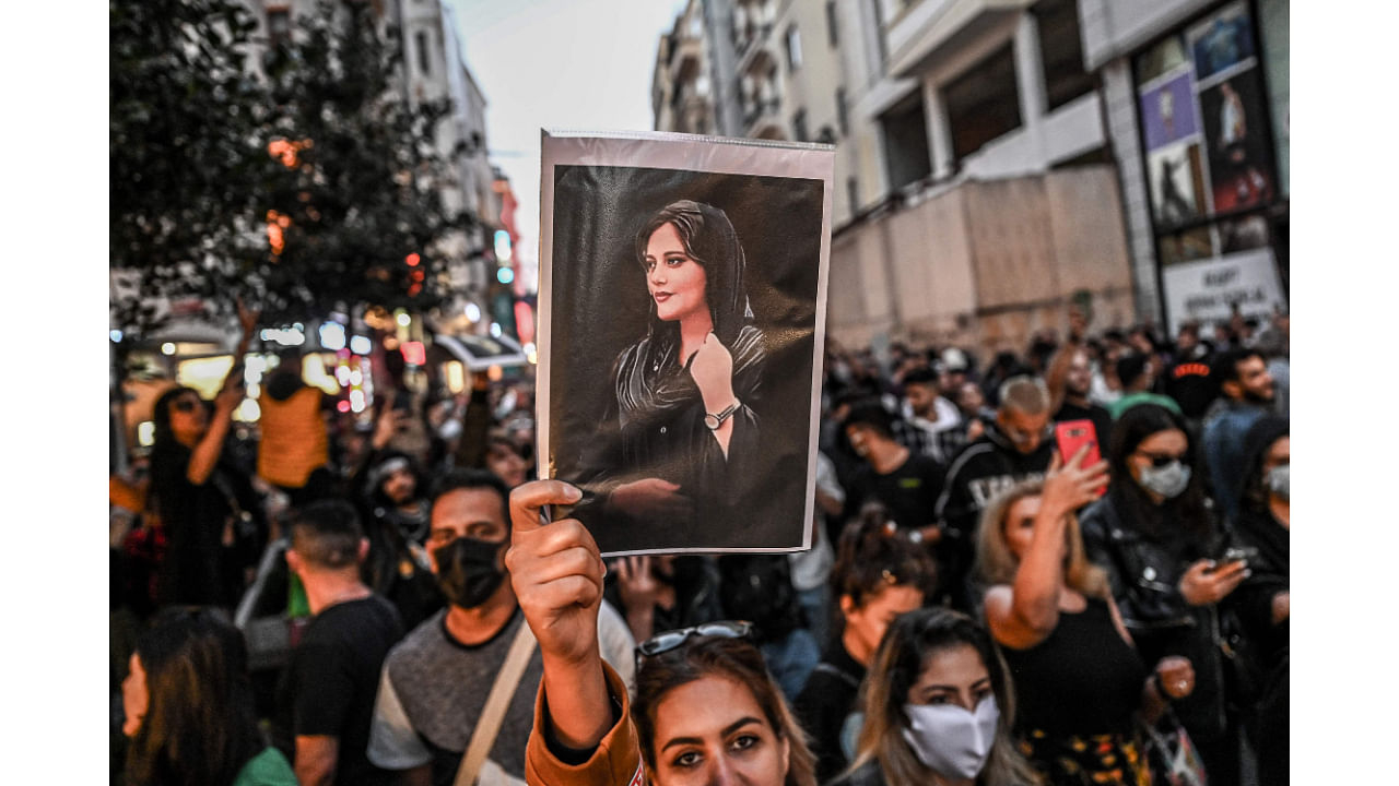 In this file photo, a protester holds a portrait of Mahsa Amini during a demonstration in support of Amini, a young Iranian woman who died after being arrested in Tehran by the Islamic Republic's morality police. Credit: AFP Photo