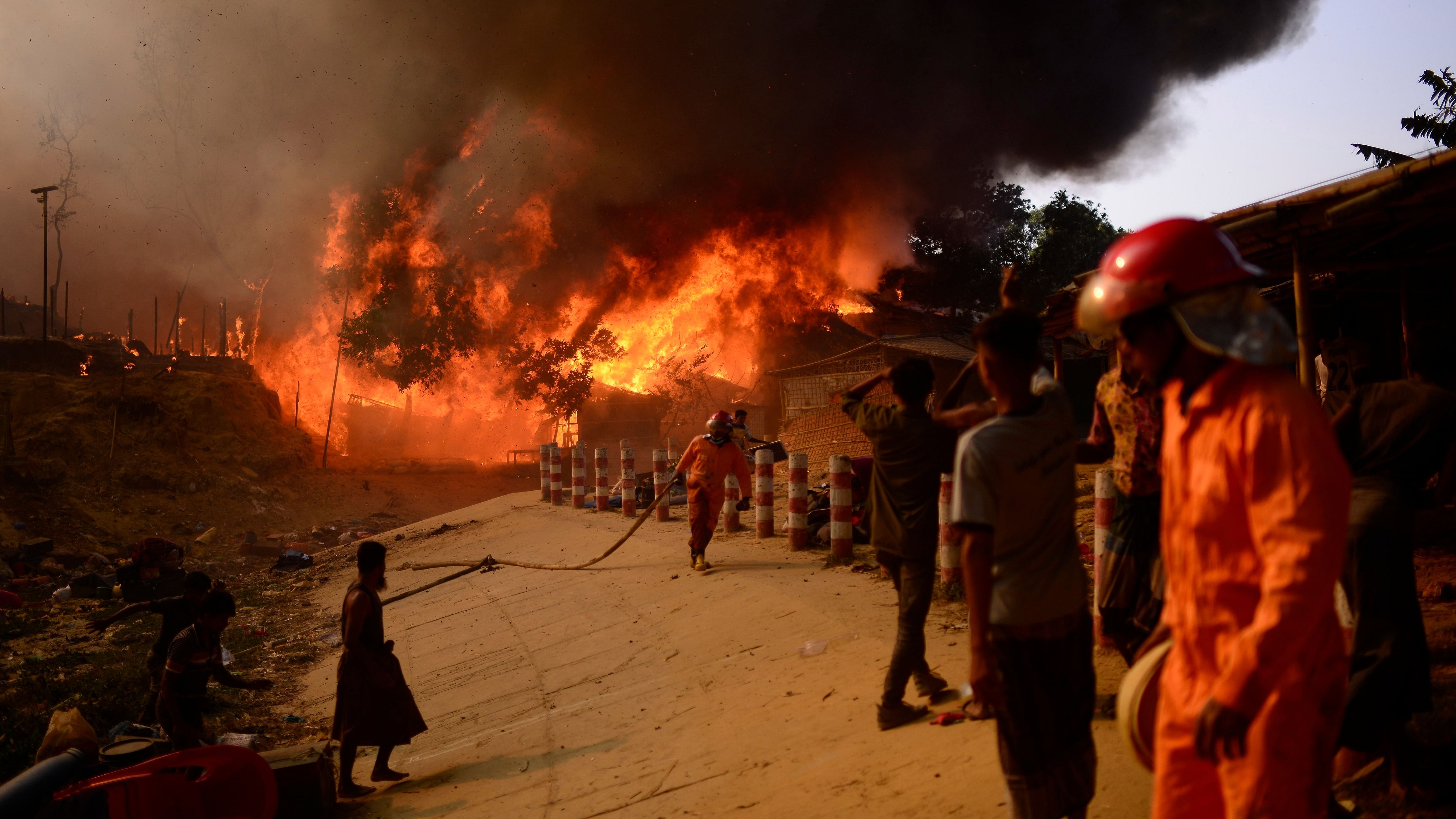 Rohingya refugees try to douse a major fire in their Balukhali camp at Ukhiya in Cox's Bazar district, Bangladesh, Sunday, March 5, 2023. Credit: AP Photo