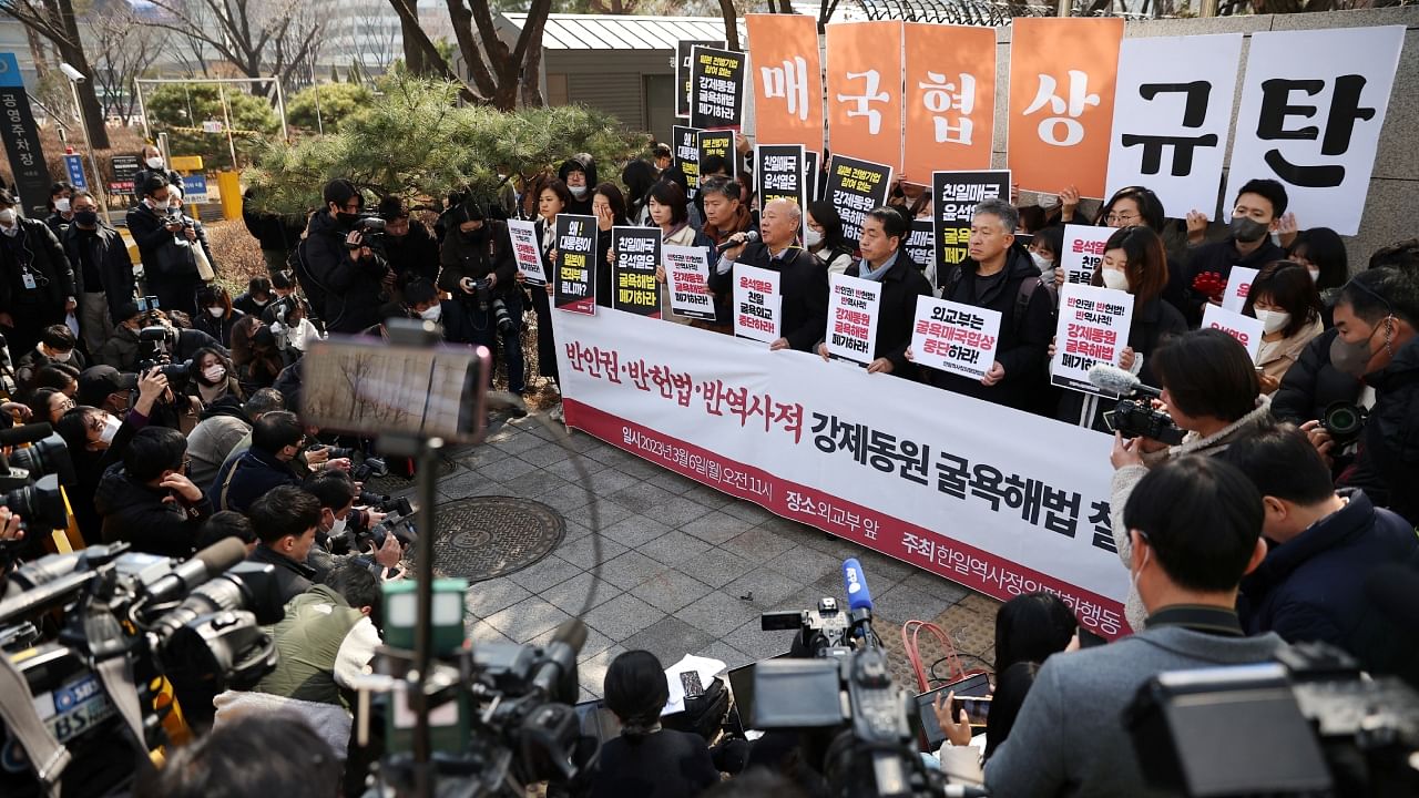 South Korean activists display a message that reads "denouncing anti-national negotiation" in front of the Foreign Ministry in Seoul, South Korea, March 6, 2023. Credit: Reuters File Photo