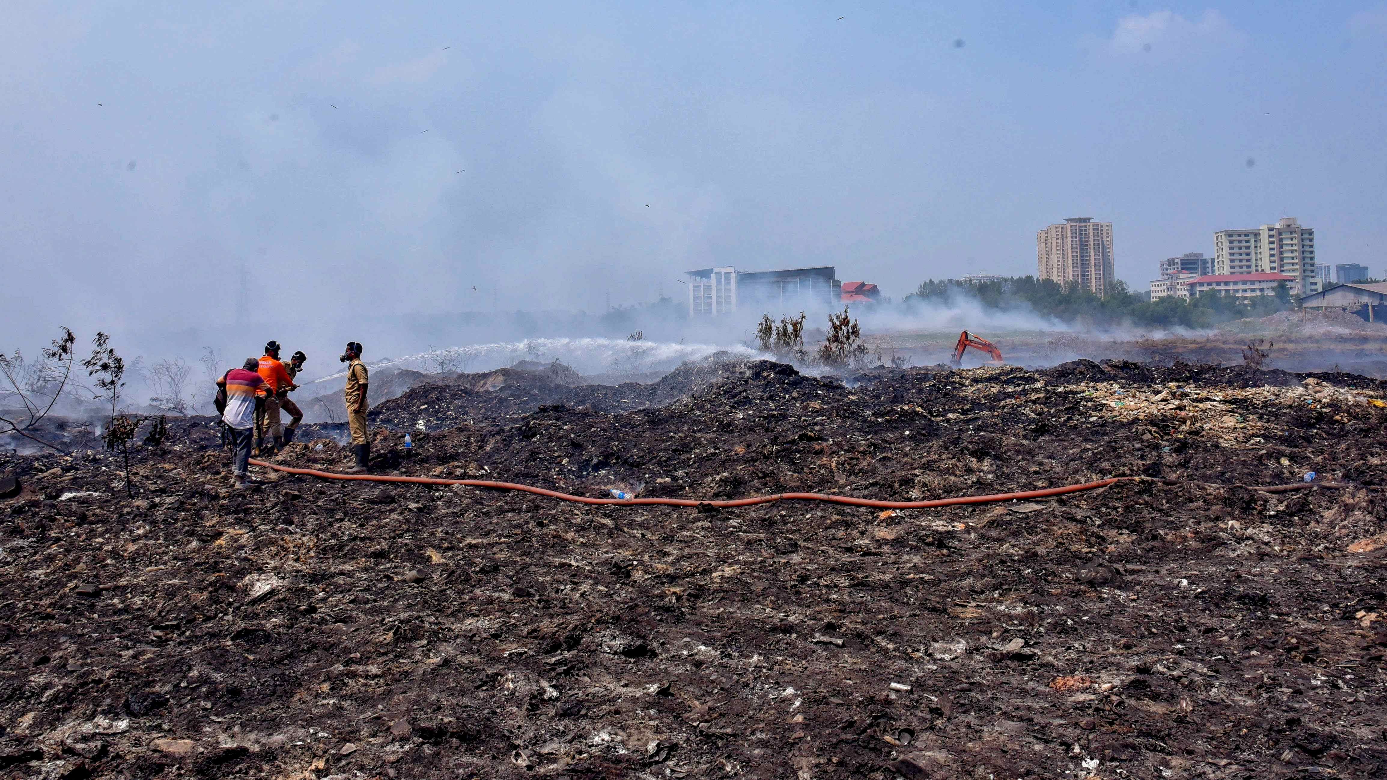 Fire and rescue personnel try to put out the fire which broke out at the Brahmapuram waste treatment plant. Credit: PTI Photo
