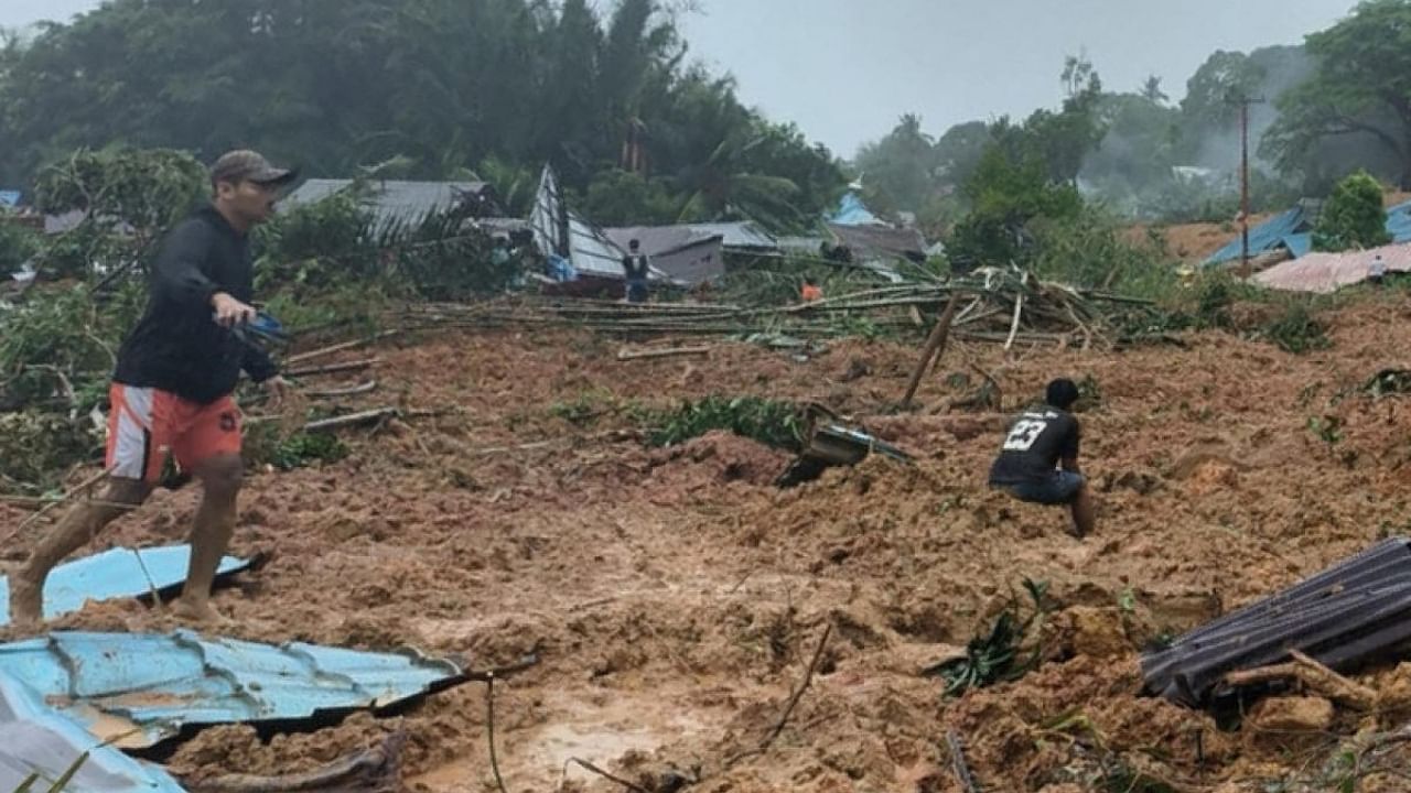 People inspecting the damage at a village that was hit by landslides in Natuna in Indonesia's Riau Province. Credit: AFP Photo/BNPB