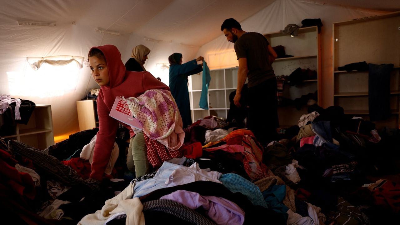 People search through donated clothes at a camp in the aftermath of the deadly earthquake in Antakya, Turkey, March 2, 2023. Reuters File Photo