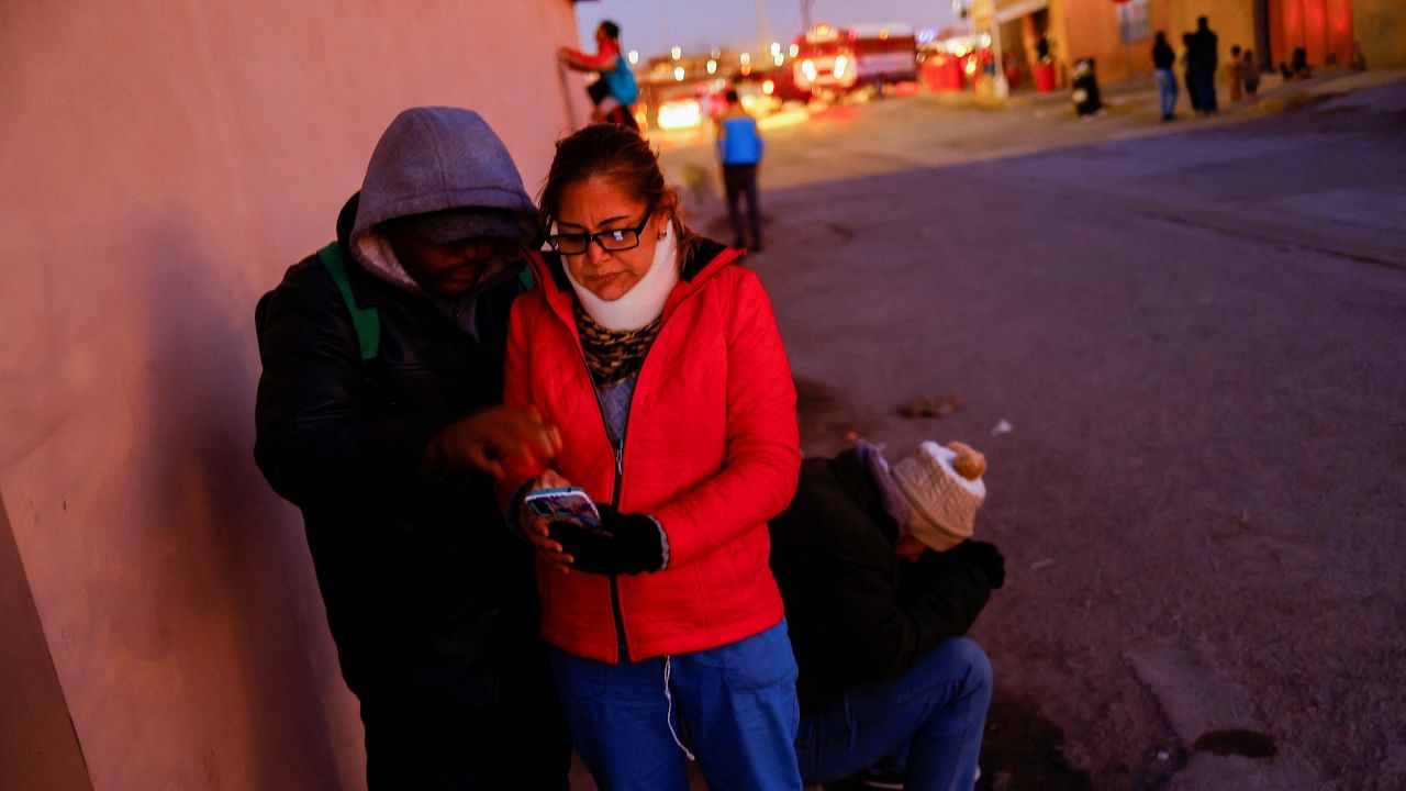 Migrants seeking asylum in the US use their phones to access the US Customs and Border Protection's (CBP) ONE application to request an appointment, outside a shelter in Ciudad Juarez, Mexico January 12, 2023. Credit: Reuters File Photo