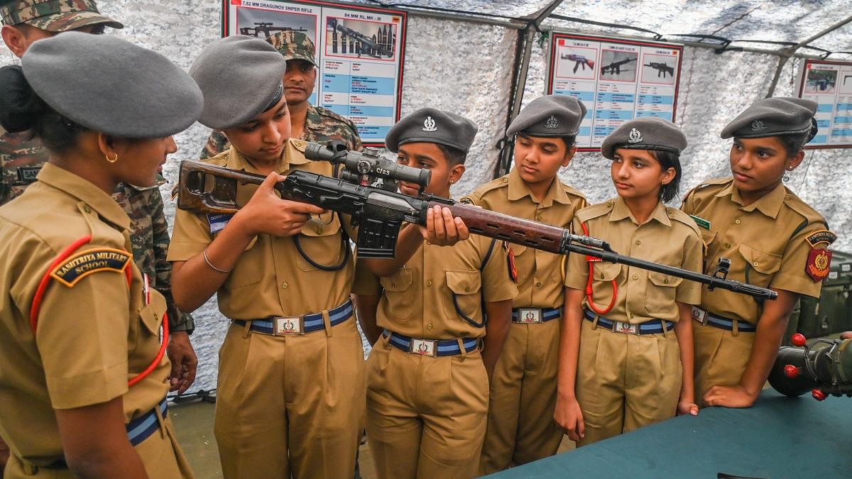 Gowri Deepa, Simran Pareda, Varsha Yadav, Harshi Patel, Aditi Nehra and Diljan Kaur, the first batch of girl cadets, try their hand at a rifle at the Rashtriya Military School in Bengaluru on Monday. DH Photo/S K Dinesh