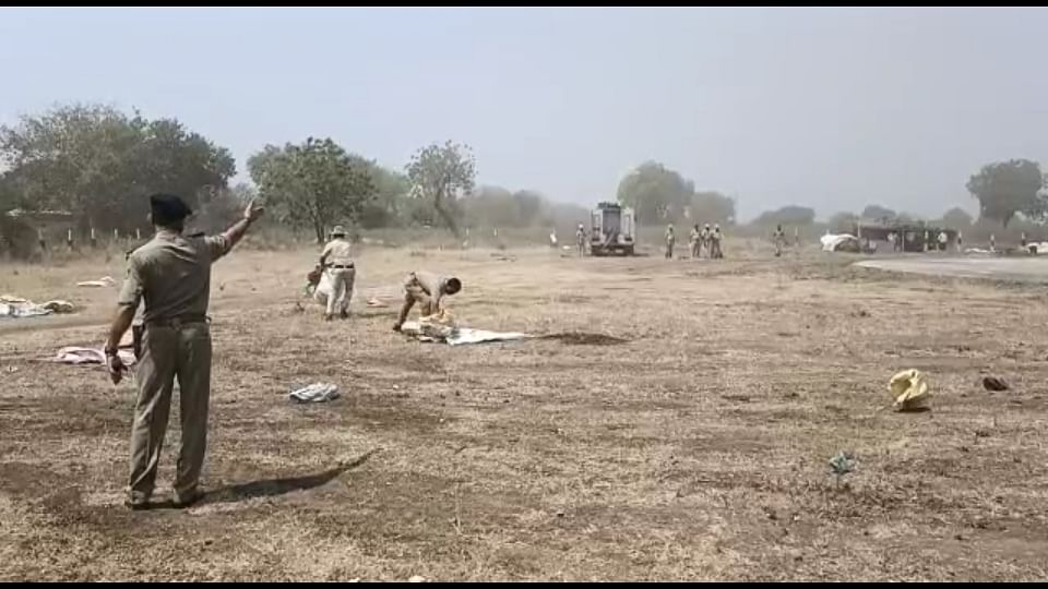 Police officials clean plastic materials surrounding the helipad in Jewargi. Credit: DH Photo