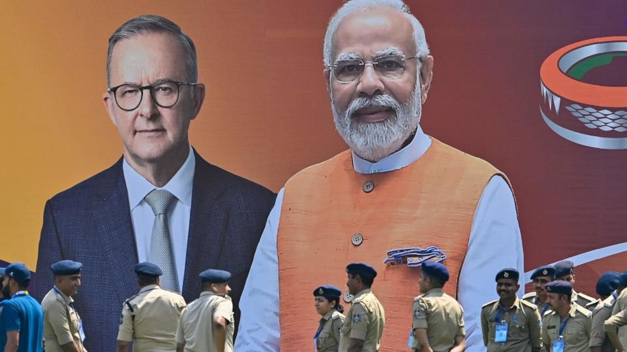 Police personnel stand next to a poster with the pictures of Australia's Prime Minister Anthony Albanese (L) and Indian Prime Minister Narendra Modi at the Narendra Modi stadium in Ahmedabad on March 7, 2023. Credit: AFP Photo