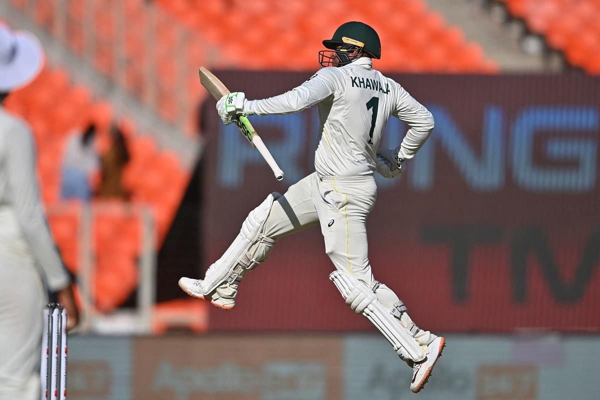 Australia's Usman Khawaja leaps in joy after completing a century against India at the Narendra Modi Stadium on Thursday. Credit: AFP Photo