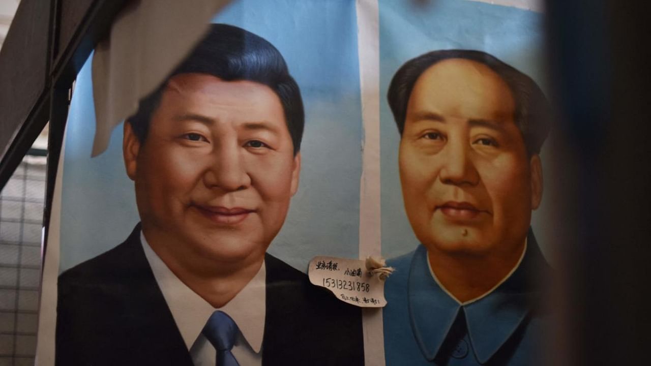 Portraits of Xi Jinping (left) and late Communist leader Mao Zedong at a Beijing marketplace. Credit: AFP Photo