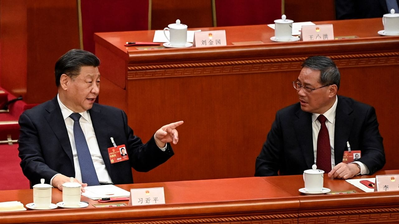 China's President Xi Jinping (L) speaks with newly-elected Premier Li Qiang (R) during the fourth plenary session of the National People's Congress (NPC) at the Great Hall of the People in Beijing on March 11, 2023. Credit: Reuters Photo
