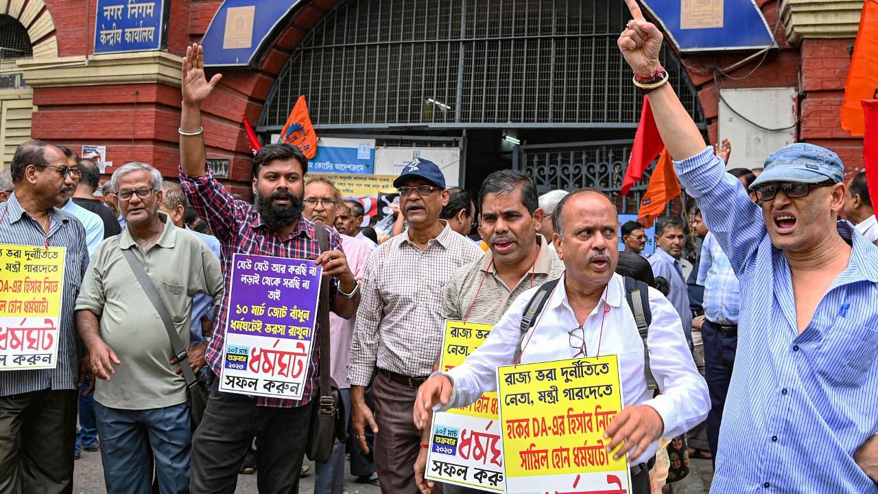 West Bengal Government employees raise slogans during their strike demanding clearance of their pending DA (Dearness Allowance), at Kolkata Municipal Corporation headquarters in Kolkata. Credit: PTI Photo