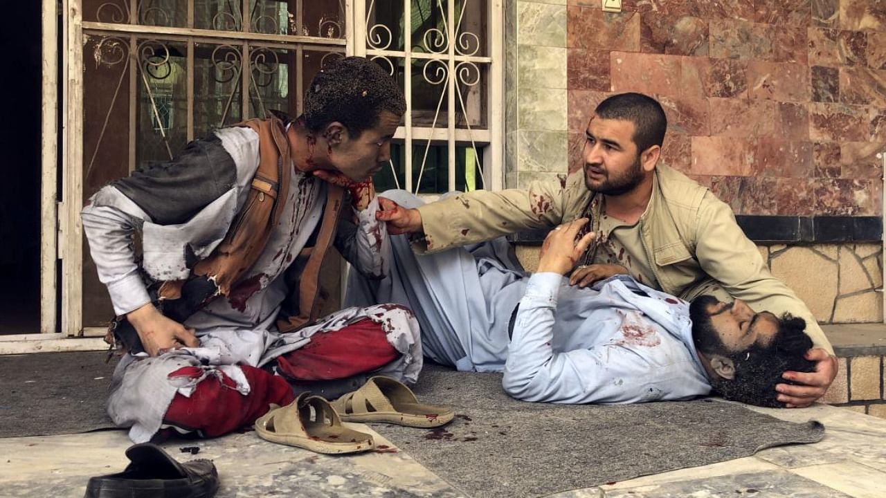 An injured man lies down after a bomb blast in Mazar-e-Sharif, the capital city of Balkh province, in northern Afghanistan. Credit: AP/PTI Photo