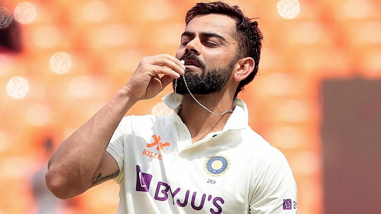Virat Kohli kisses the locket as he celebrates his century during the fourth day of the fourth cricket test match between India and Australia at Narendra Modi Stadium in Ahmedabad. Credit: IANS Photo