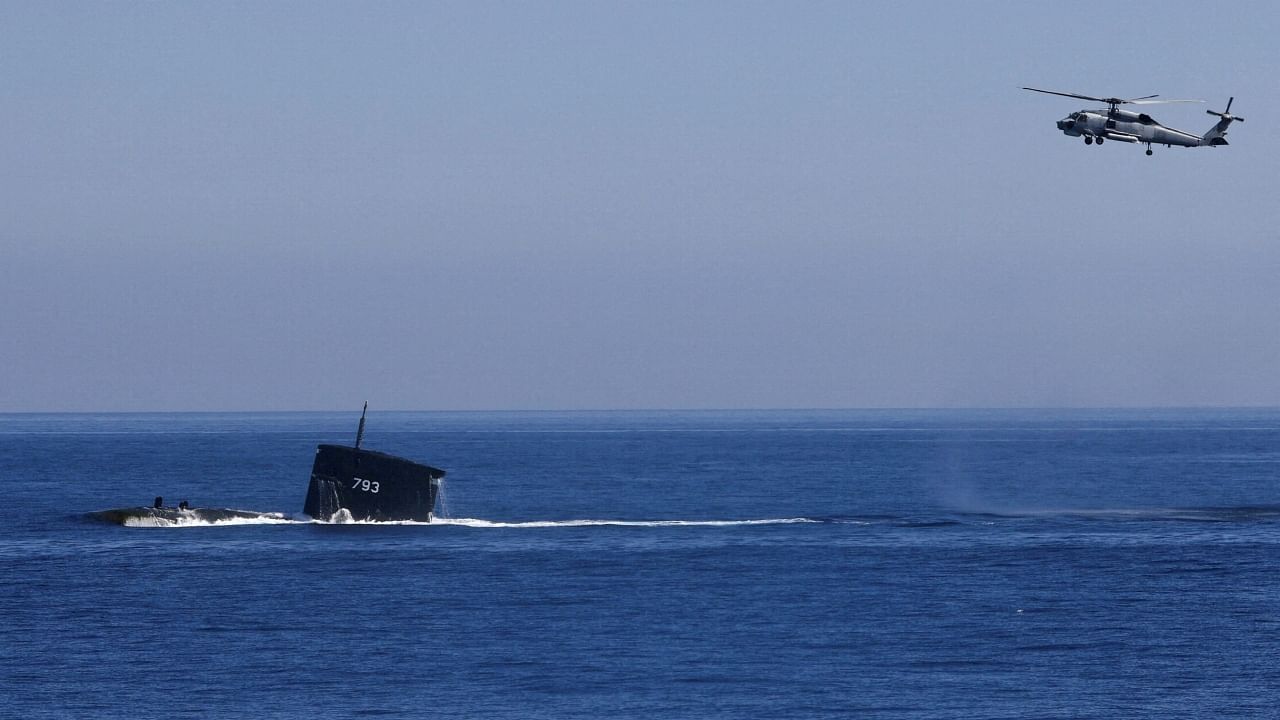 A S70C helicopter can be seen flying around SS793 submarine as part of Taiwan's main annual "Han Kuang" exercises, as 20 naval vessels including frigates and destroyers fired shells to simulate intercepting and attacking an invading force, off Taiwan's northeastern coast, in Yilan, Taiwan, July 26, 2022. Credit: Reuters File Photo