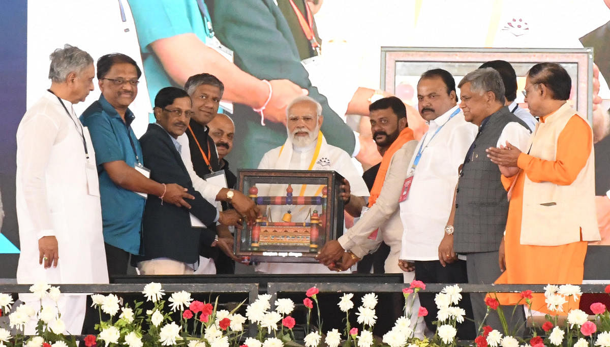 Prime Minister Narendra Modi being gifted with the famous Kalghatgi wodden cradle during the inauguration of IIT-Dh new campus at Mummigatti near Dharwad on Sunday. Credit: DH Photo