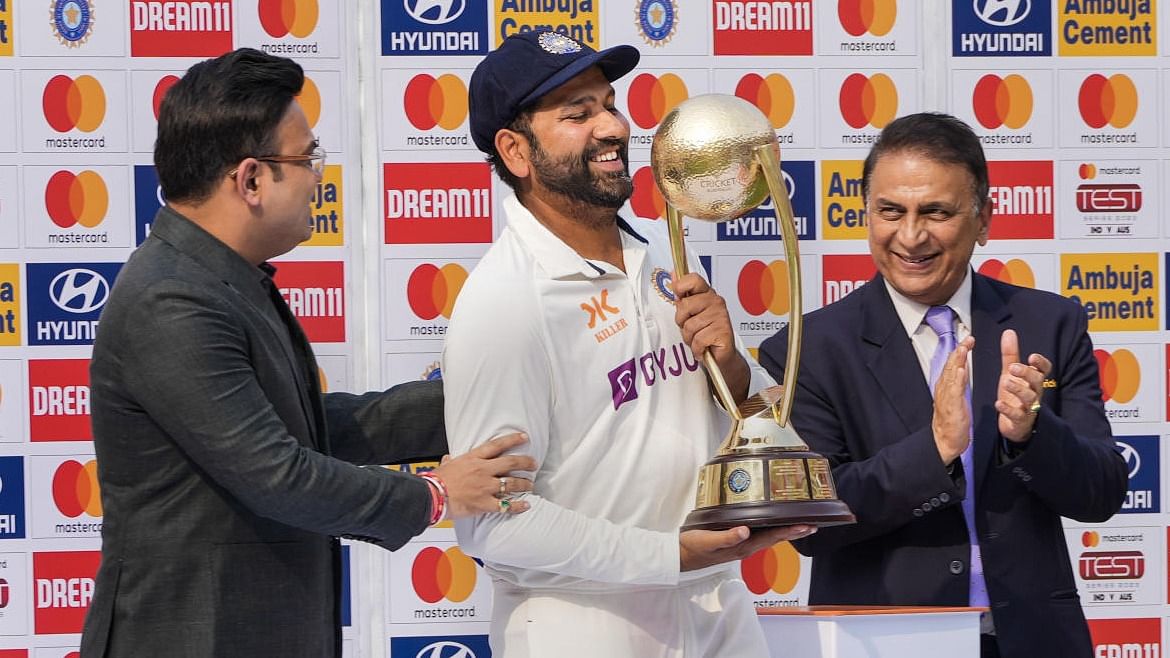 Rohit Sharma (centre) with the trophy alongside Sunil Gavaskar at the Narendra Modi stadium on Monday. Credit: PTI Photo