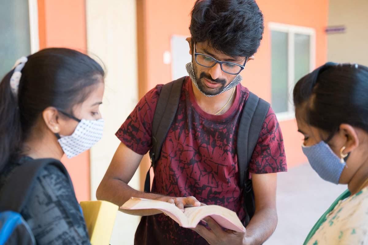 Group of college students discussing the topic on a college corridor